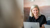 Young woman in an office looking happy by her computer